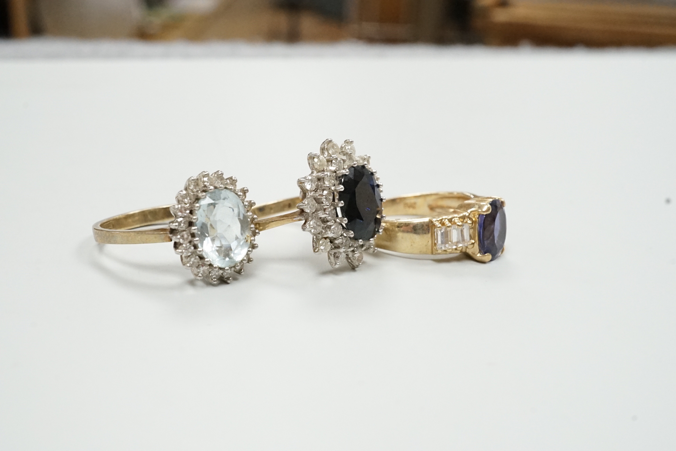 Three assorted modern 9ct gold and gem set dress rings, including sapphire and diamond chip set oval cluster, size K/L, gross weight 9.6 grams.